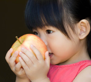 child smelling an apple