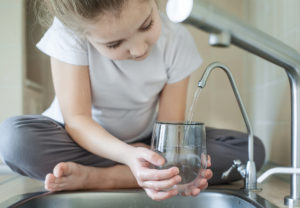girl filling cup with water