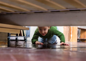 child looking under furniture