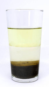glass of water oil sand
