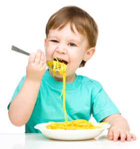 child eating pasta