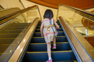 girl rides the escalator