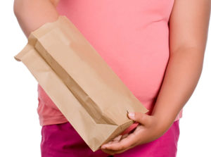 child with hand in paper bag