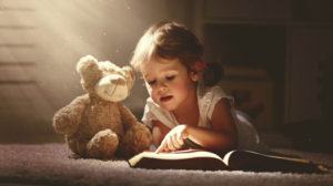 child reading to stuffed animal