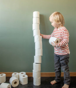 child stacking toilet paper rolls