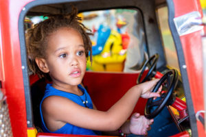 girl driving toy car