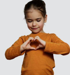 girl making heart shape with hands