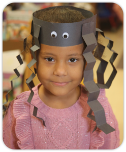 girl wearing a spider hat