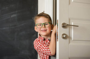 smiling boy opening a door