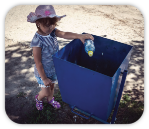 Child putting a bottle in recycle bin