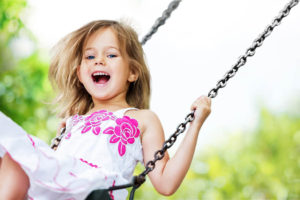 Smiling girl on a swing