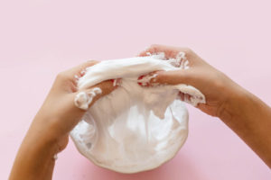 a child squeezing shaving cream in a plastic bag